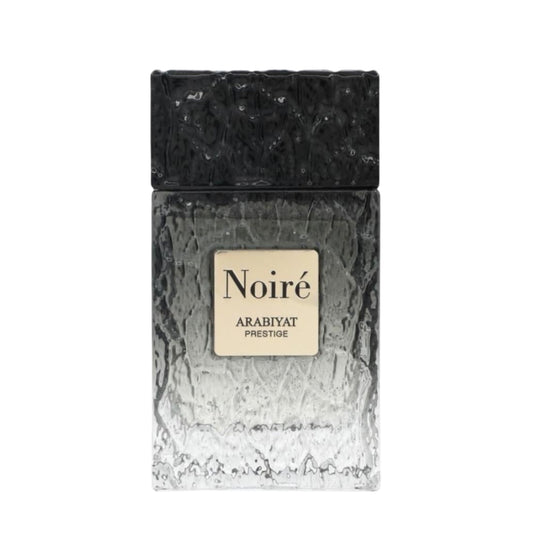 A rectangular perfume bottle labeled 'Noiré ARABIYAT PRESTIGE' with a textured black cap and a frosted glass body that fades from dark gray to white, shown on a plain white background.